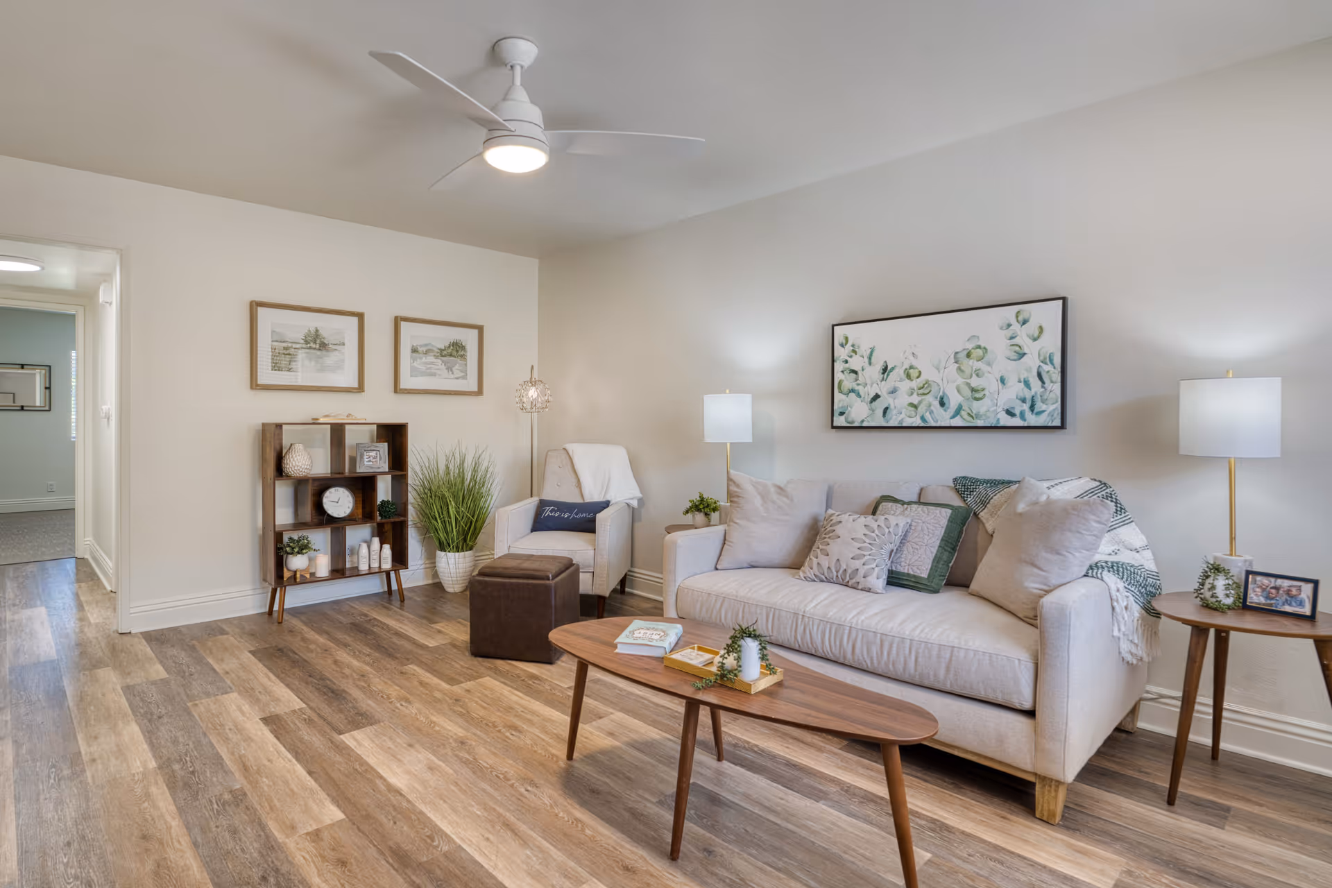 Bright, cozy living room with beige sofa, coffee table, and plants.