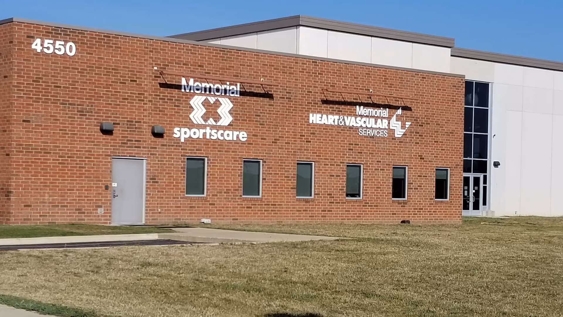 Brick facility facade with Memorial signage and multiple windows at the front.