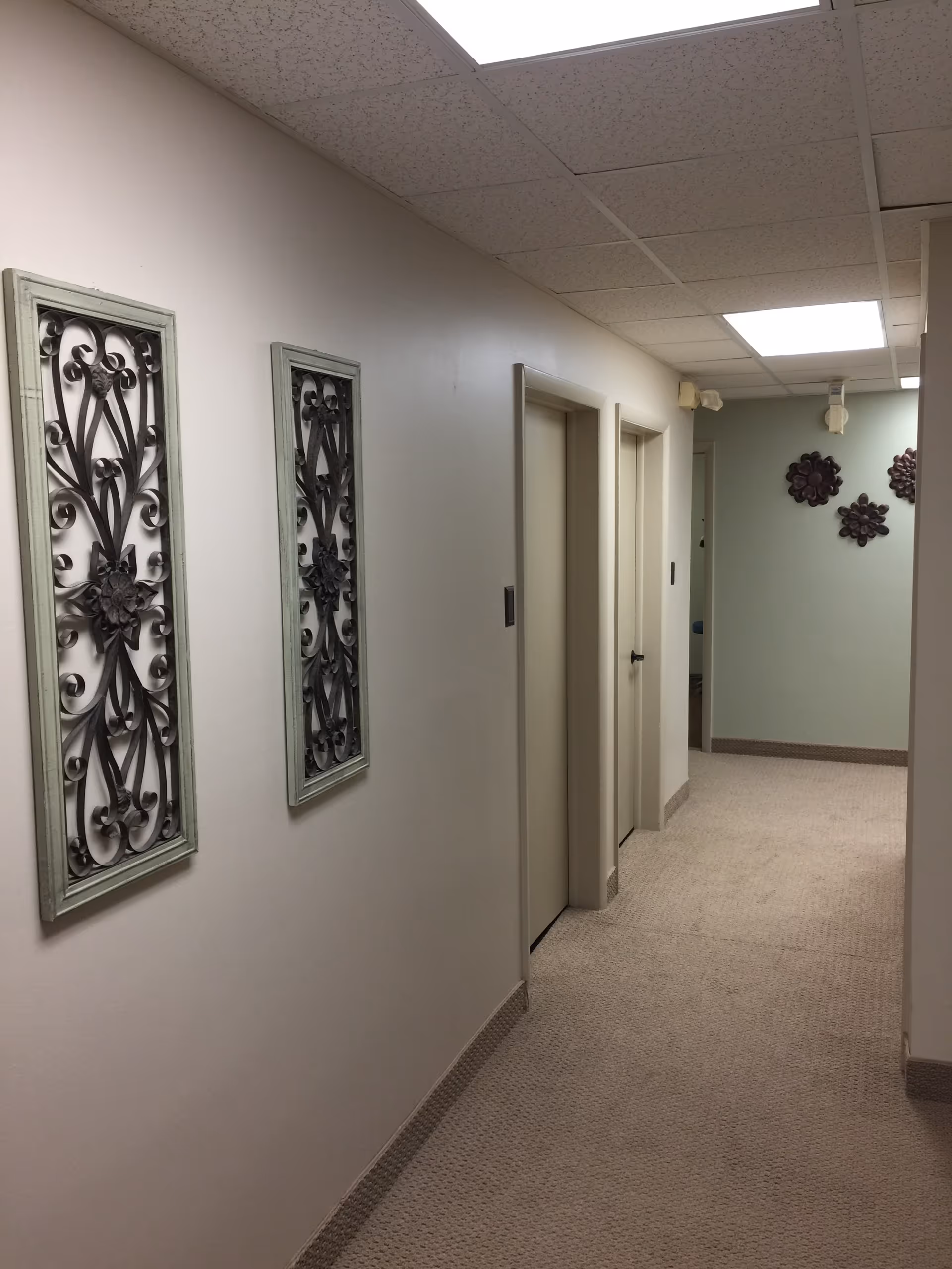 A clean hallway inside a senior facility with decorative wall panels and doors.