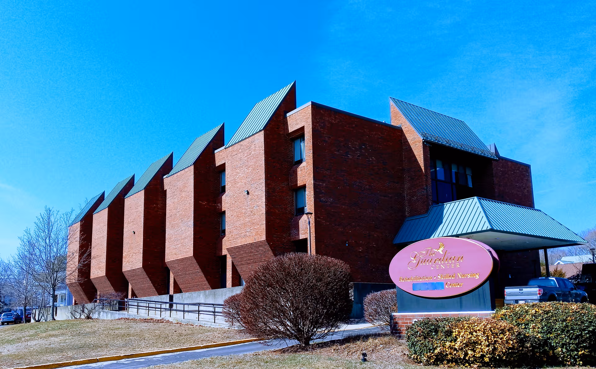 Exterior view of The Guardian Center building with a purple sign under a blue sky.
