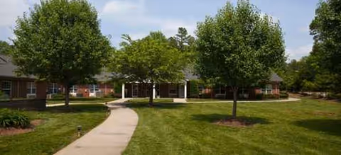 Brookdale Union Park exterior: curved walkway, brick building, and green lawn with trees.