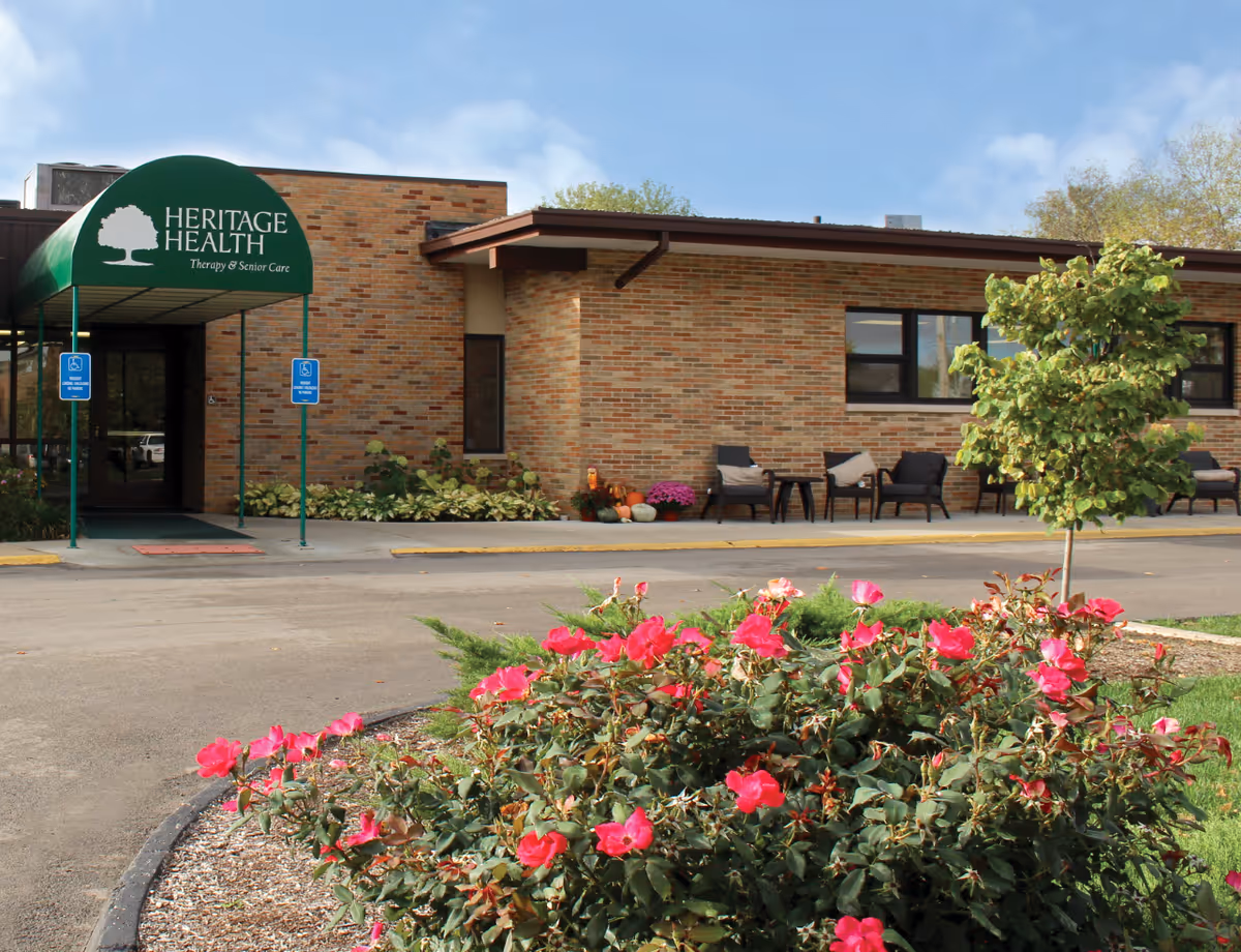 Brick facility exterior with Heritage Health sign and outdoor seating.