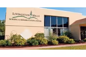 Exterior view of Livingston Hills Nursing and Rehabilitation Center with landscaping and large windows.