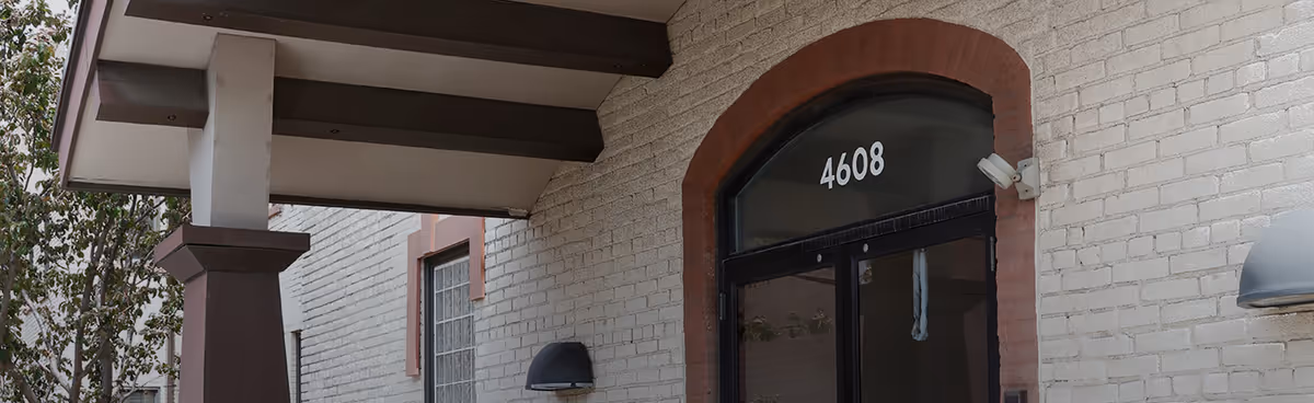 Exterior entrance to Hummingbird Home Care facility with a covered doorway and brick walls.