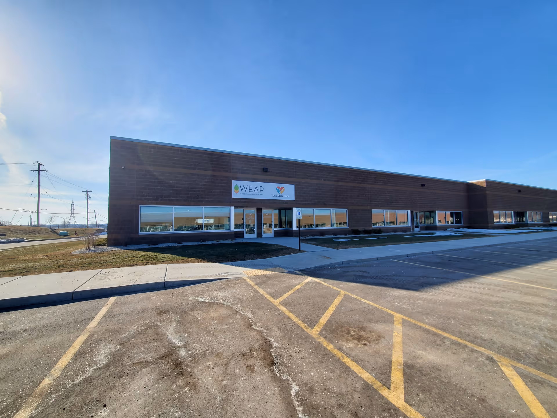 Single-story brick facility with glass storefront and a spacious parking lot.