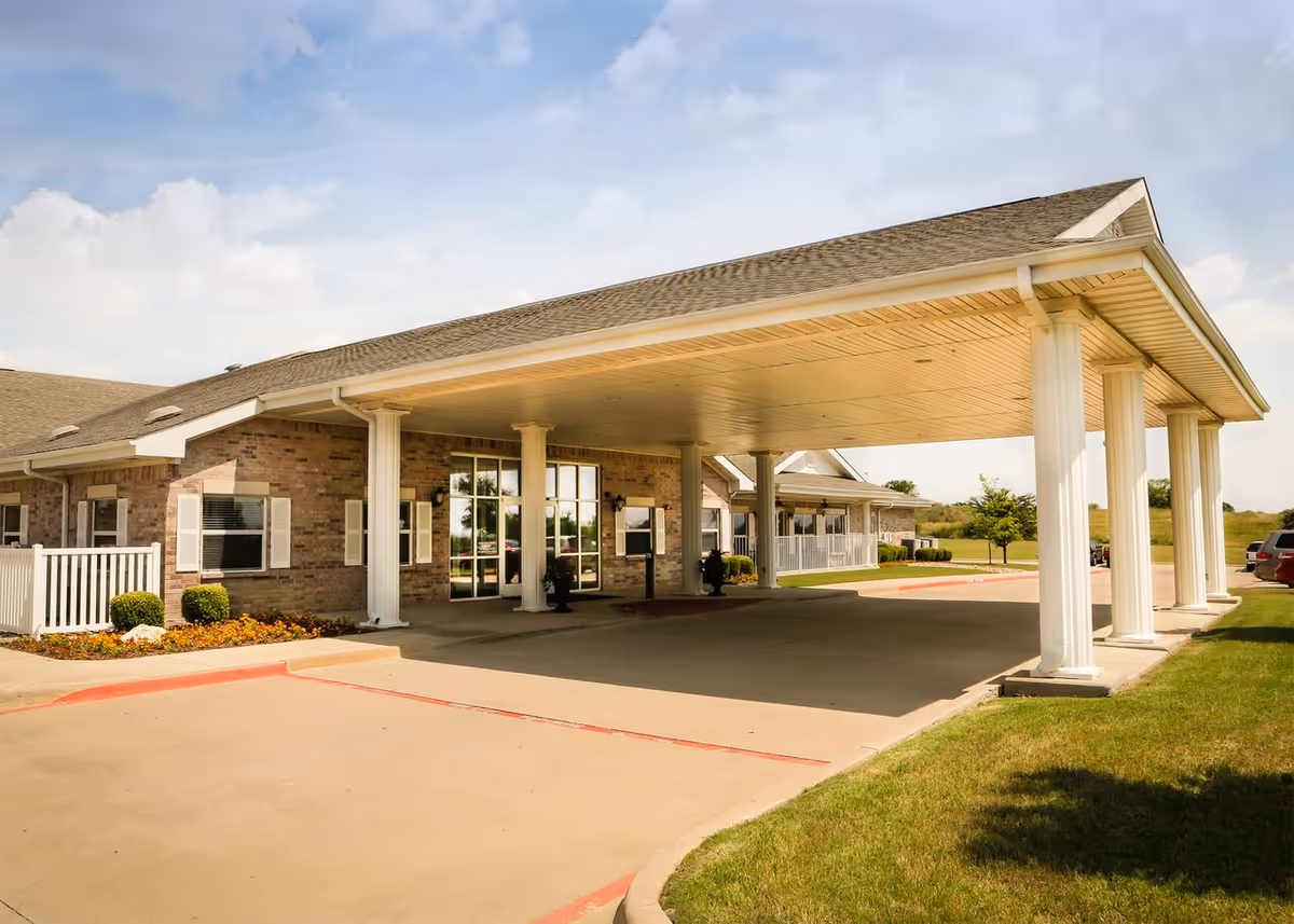 Brick senior living facility with white columns and a covered entrance.