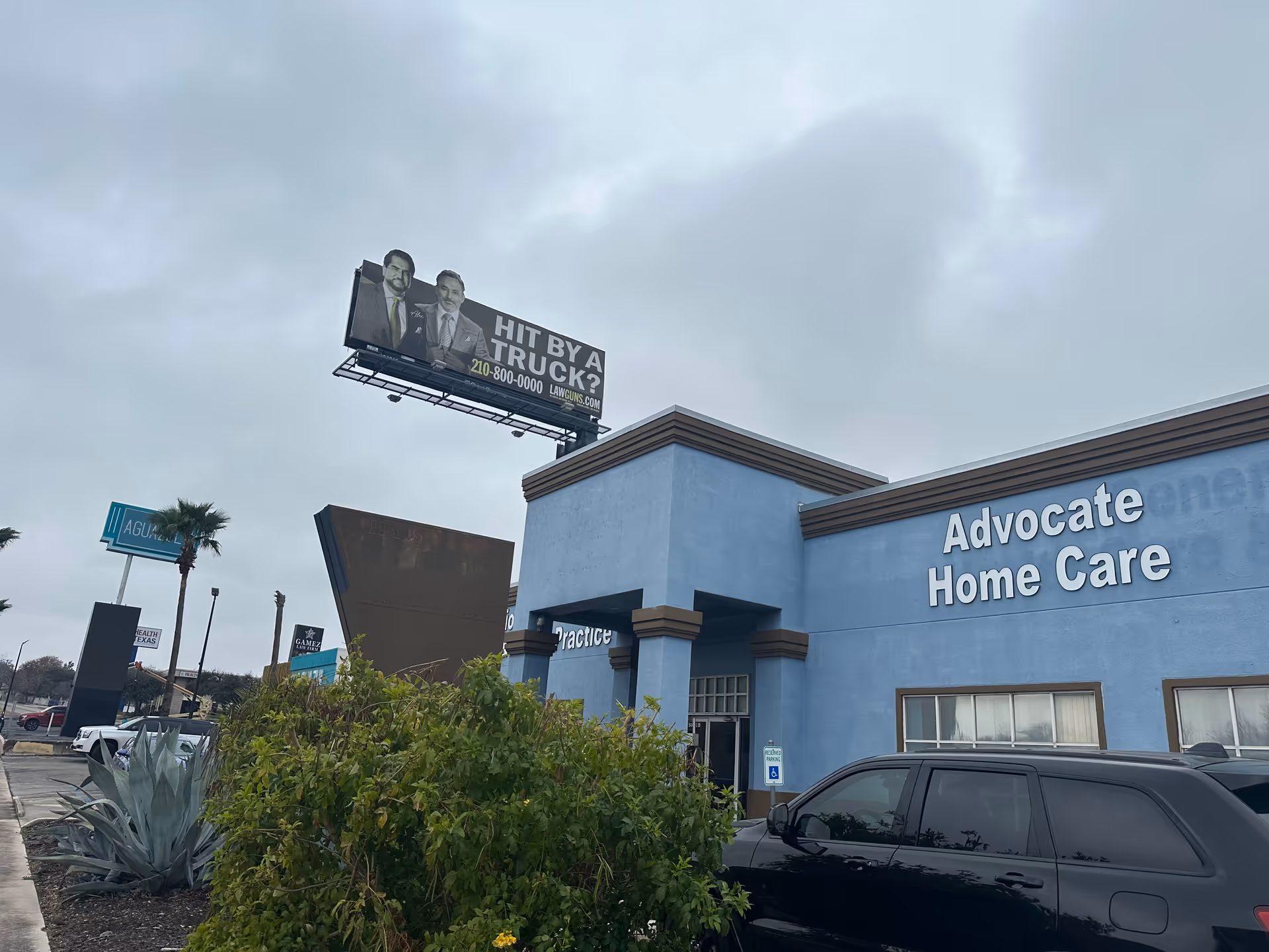 Blue Advocate Home Care building with sign and parked SUV in foreground.