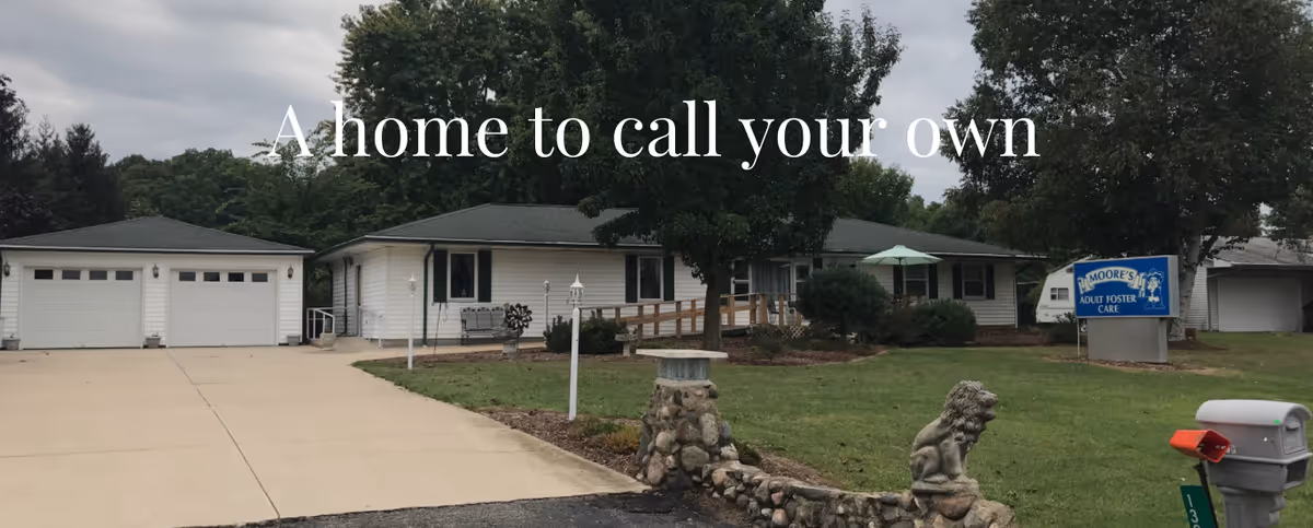 Single-story Moore's Adult Foster Care facility with driveway, lawn, and front sign