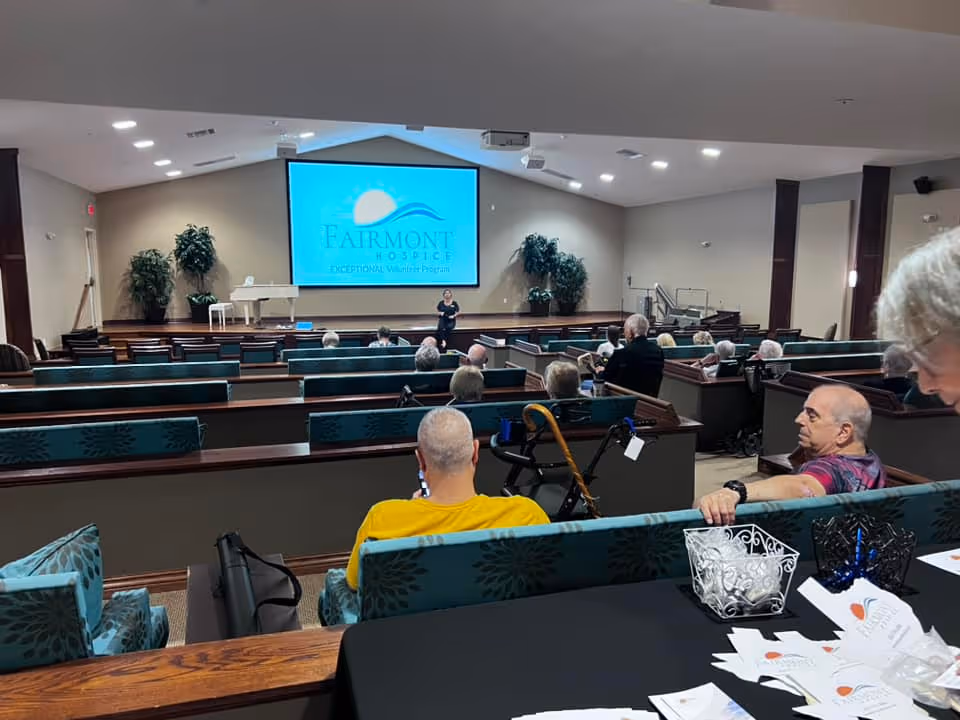 Audience seated in an interior hall watching a presenter on a screen at Fairmont Hospice Clearlake.