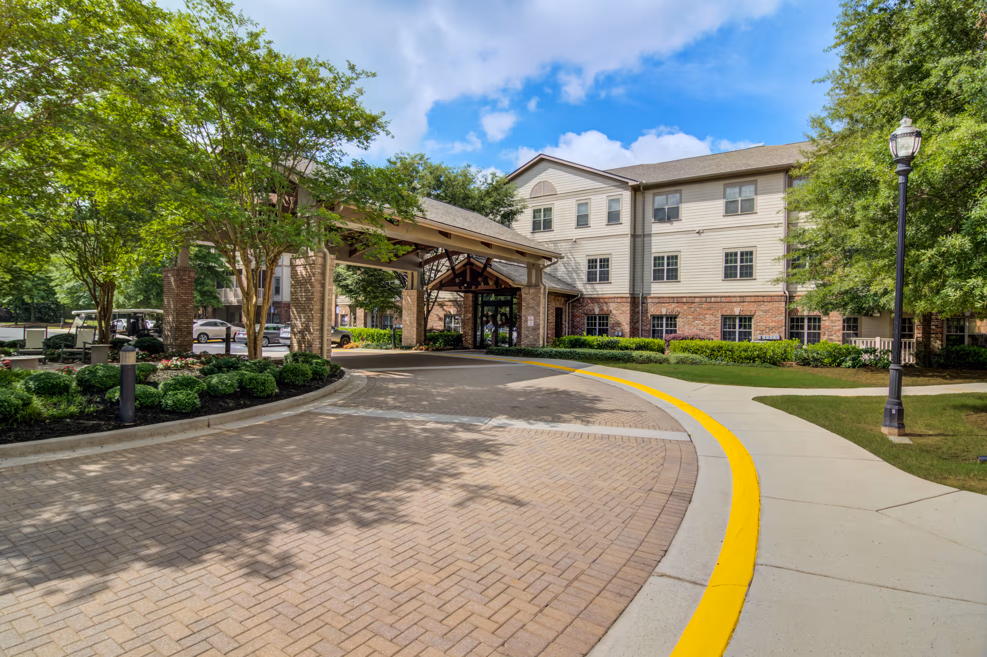 Exterior view of Arbor Terrace Peachtree City with a covered entrance and landscaped surroundings.