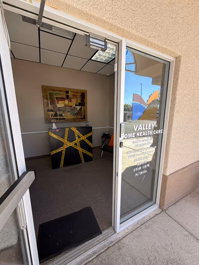 Open doorway reveals an interior reception area with artwork and a front desk.