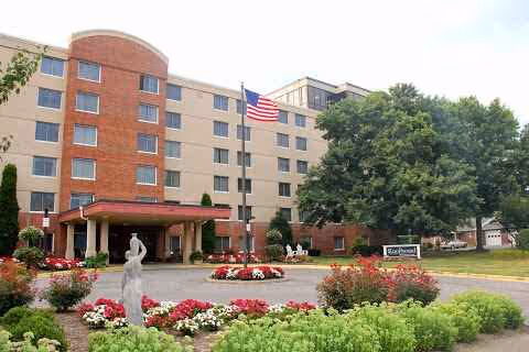 Front exterior of Richfield Living facility with entrance and landscaped garden.