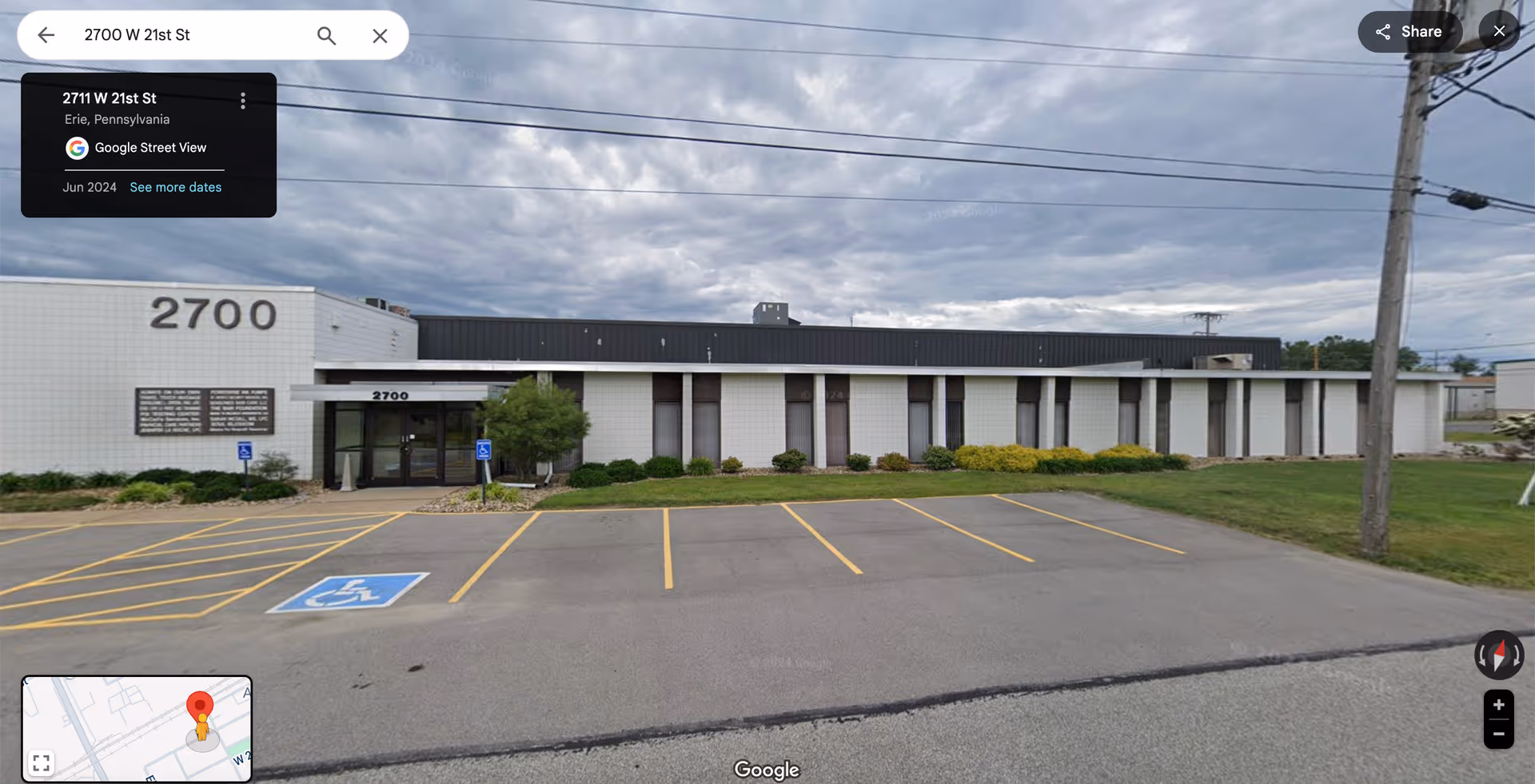 Single-story building exterior with parking lot and neatly trimmed shrubs.
