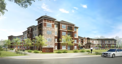 Exterior view of SilverCreek on Main senior living facility with brick and stone facade and landscaping.