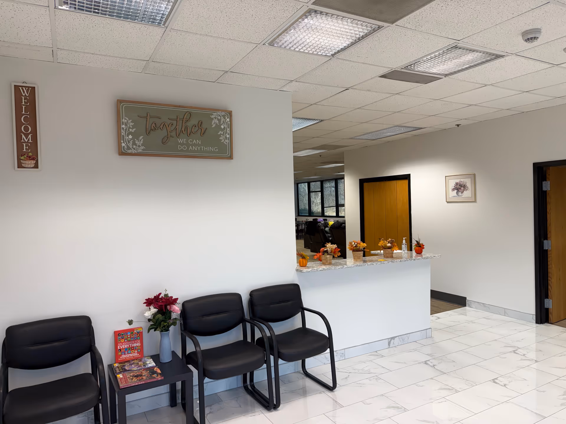 Indoor lobby area of Arbor Health Services with chairs, a reception counter, and autumn decor.