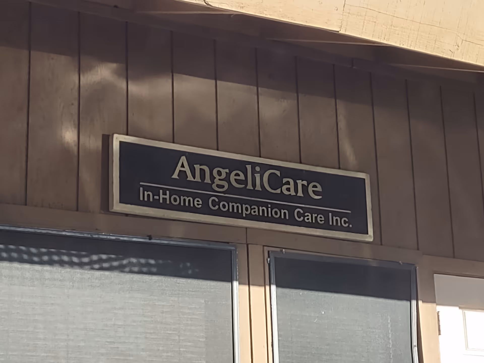 Exterior of the facility with Angelicare sign on brown siding.