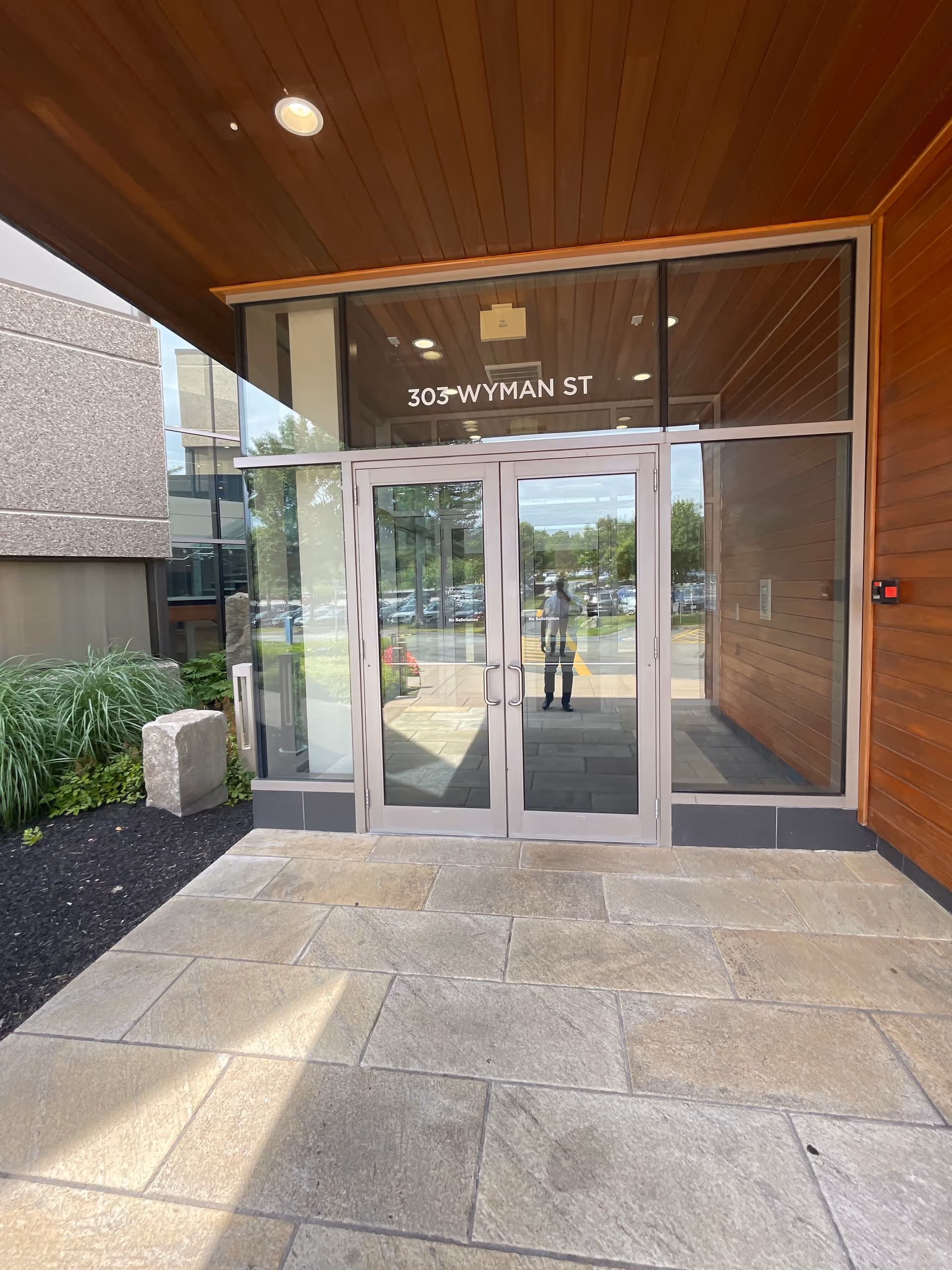 Glass entrance doors for Mercy Hearts Home Care at a modern building front.