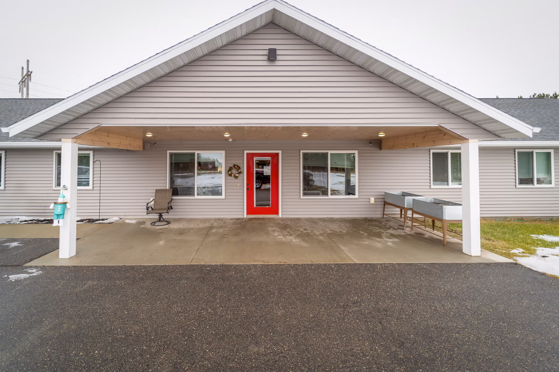 Front view of a single-story senior living facility with a red front door.