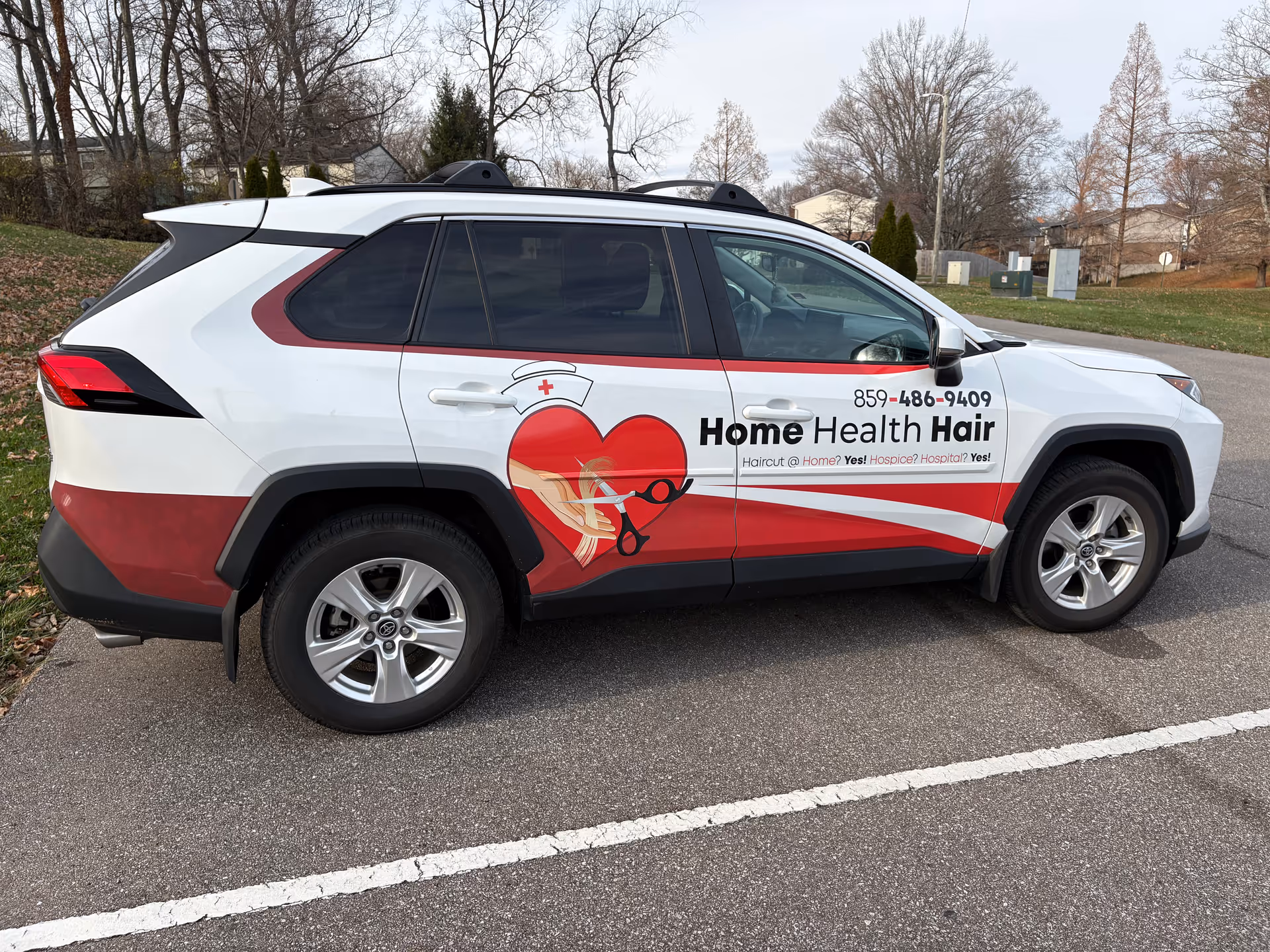White SUV van with red Home Health Hair branding parked in a lot