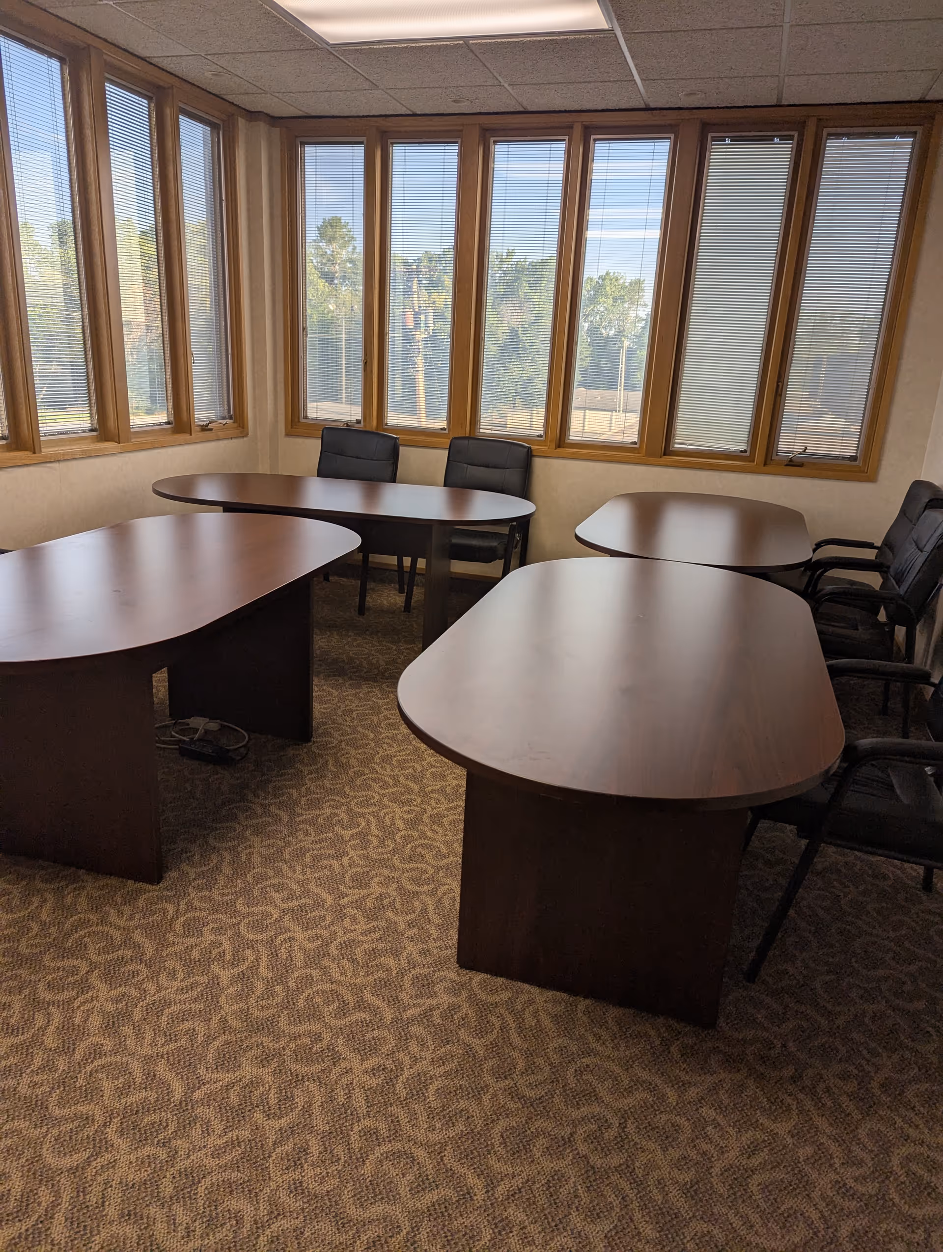 Interior of a senior living facility with wooden tables and chairs by windows.