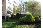 Exterior view of a senior living building with manicured lawn and trees.