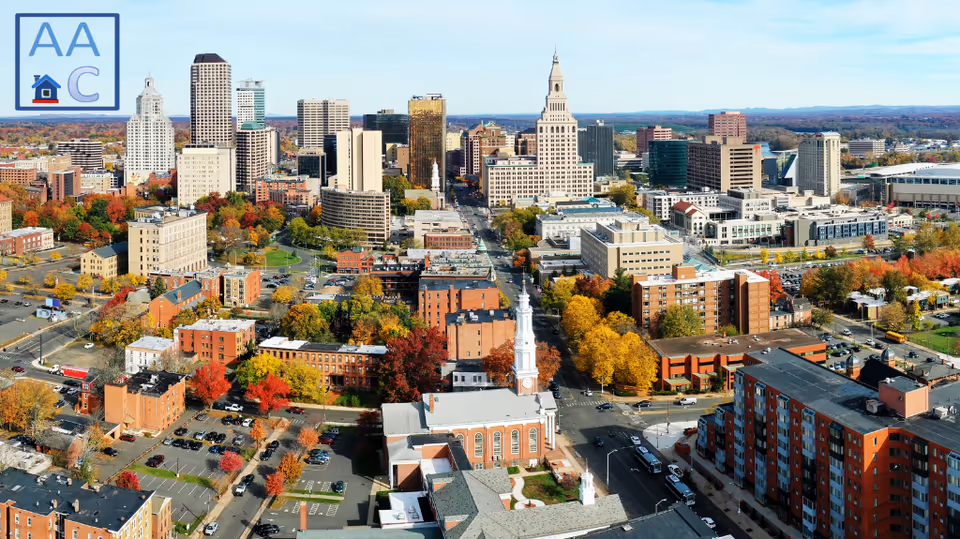 Aerial cityscape with tall buildings and colorful autumn trees.