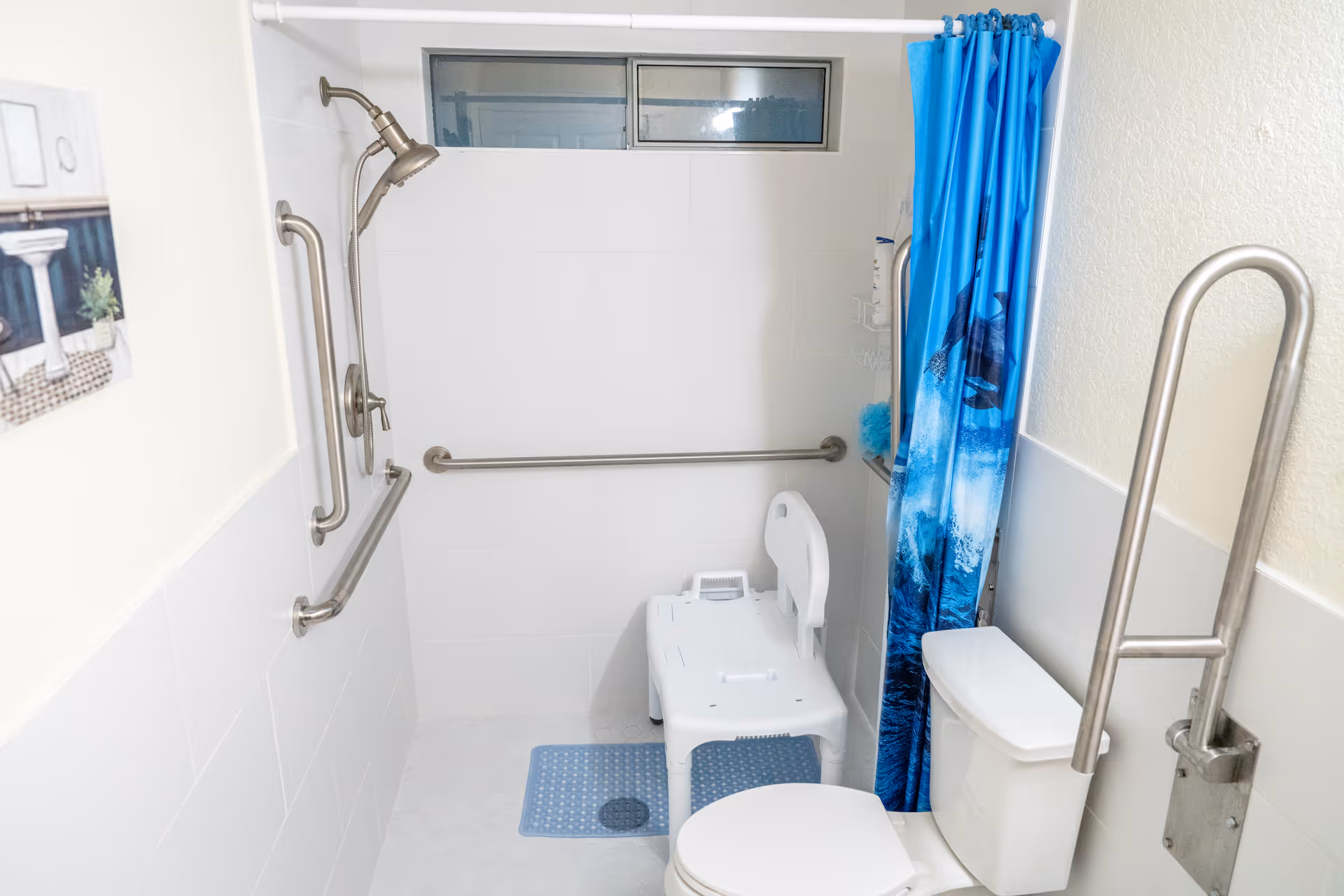 Accessible bathroom with grab bars, shower, blue curtain, and raised toilet seat.