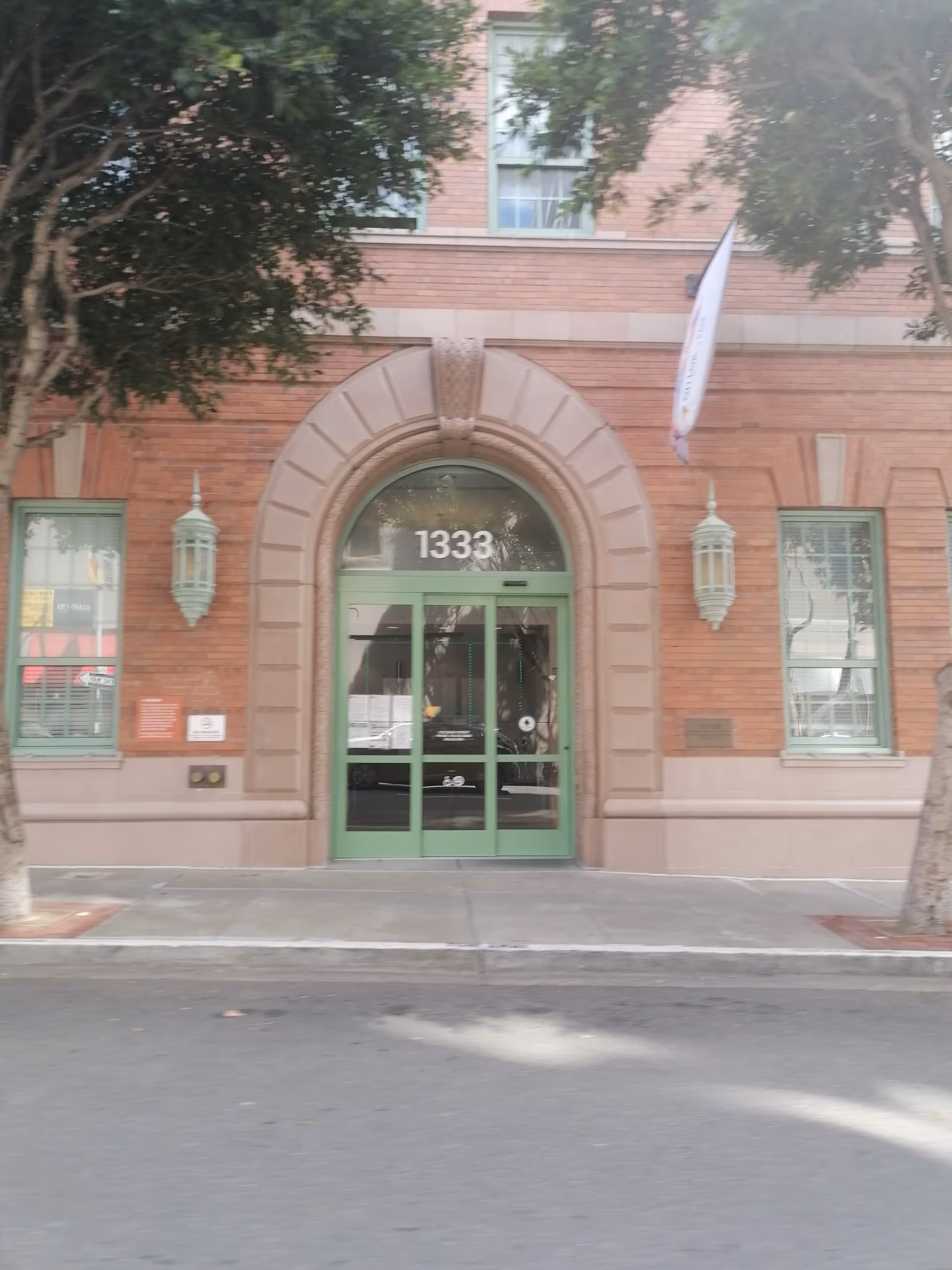 Brick building entrance with arched doorway and green doors labeled 1333.