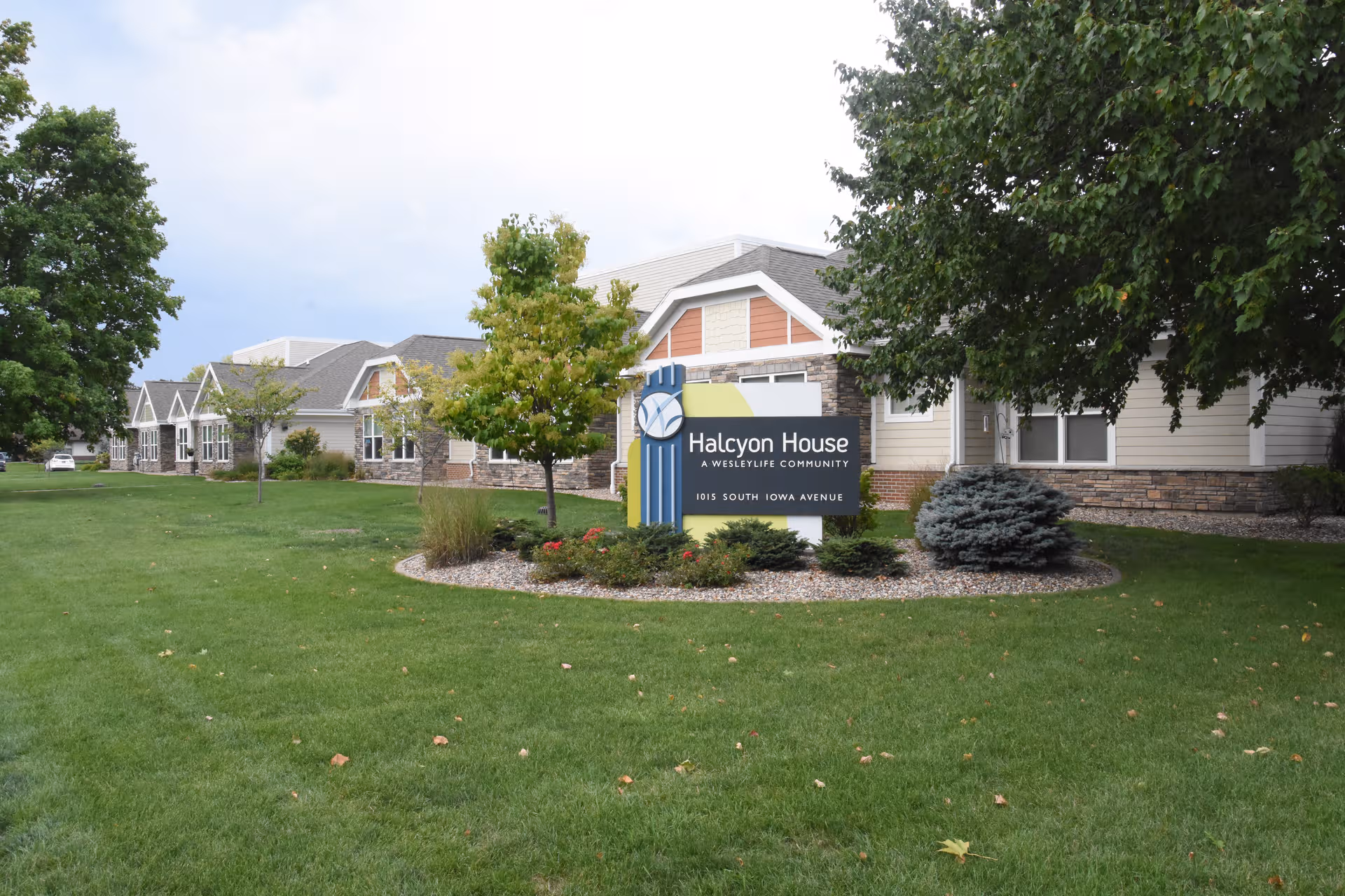 Exterior view of Halcyon House with sign, lawn, and trees.