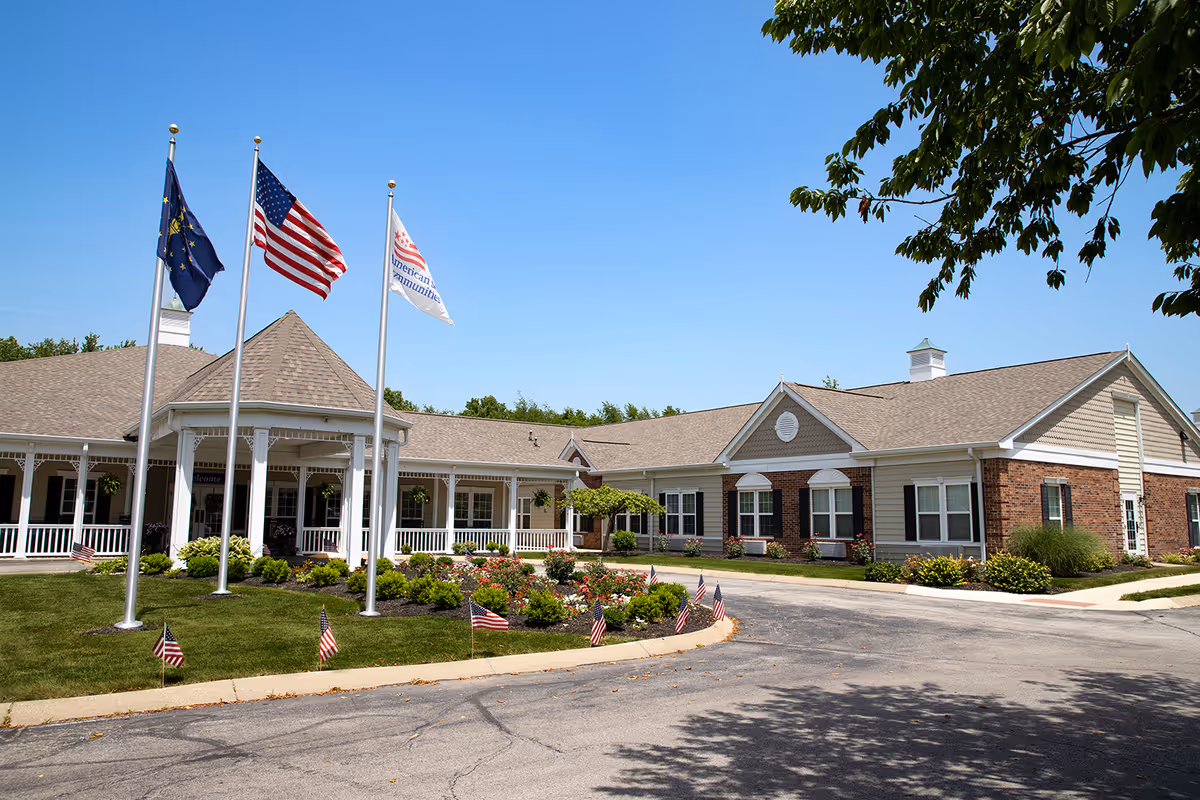 The Commons at Honey Creek exterior building front with flags and landscaped entrance.