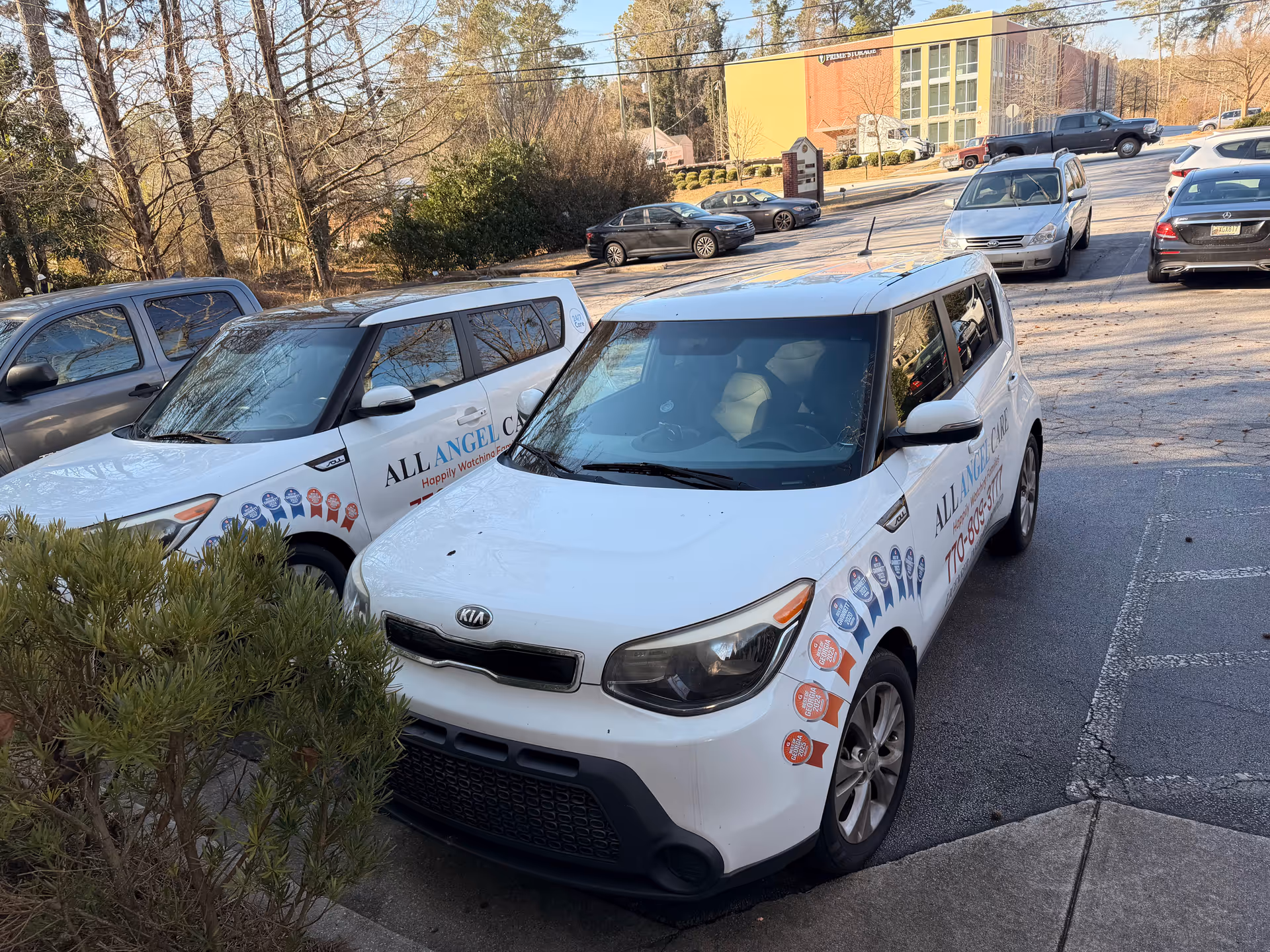 Two white All Angel Care vans parked in a lot outside the facility.