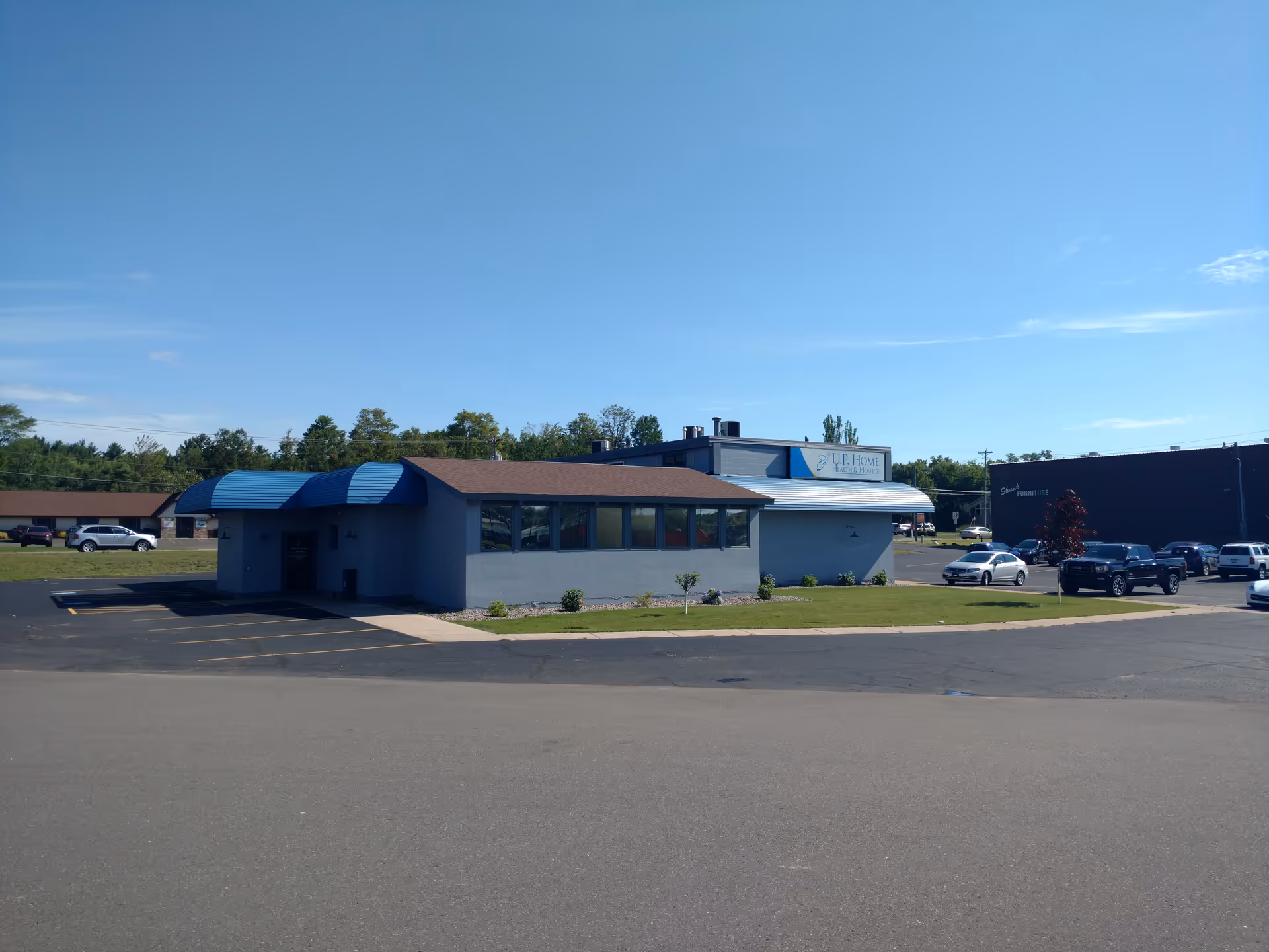Exterior view of U.P. Home Health & Hospice building with blue awnings.