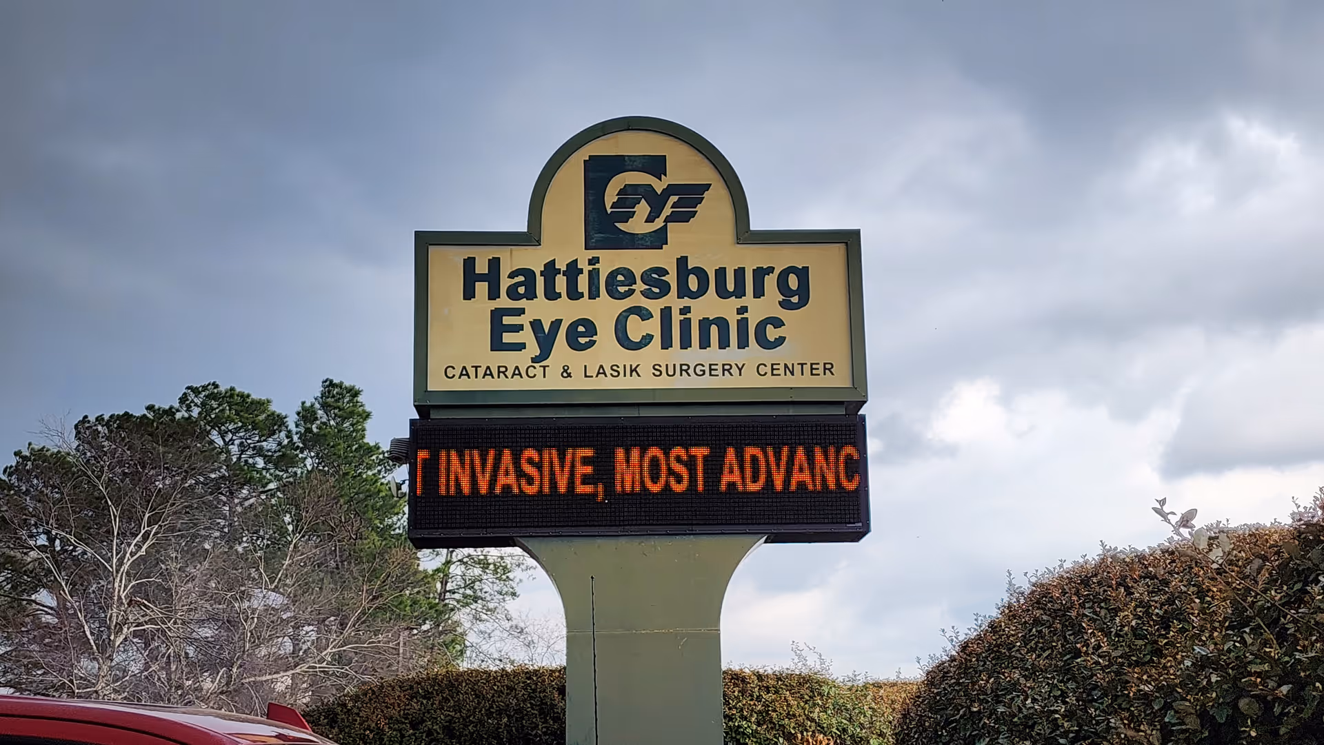 Outdoor sign for Hattiesburg Eye Clinic featuring an LED marquee beside trees.