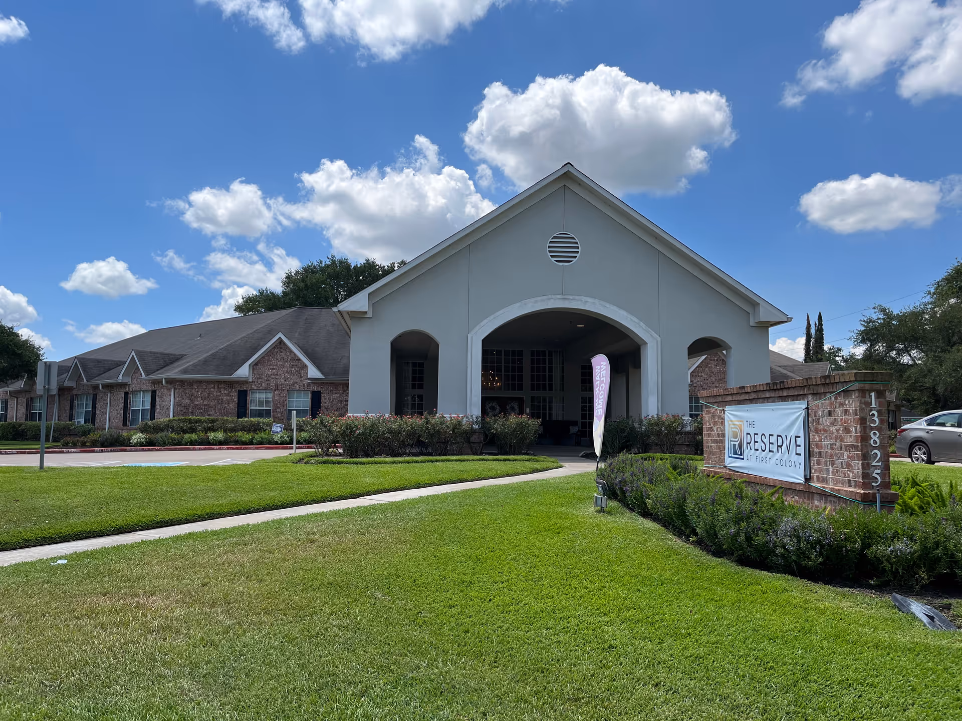 Front view of The Reserve at First Colony assisted living building with sign and landscaping.