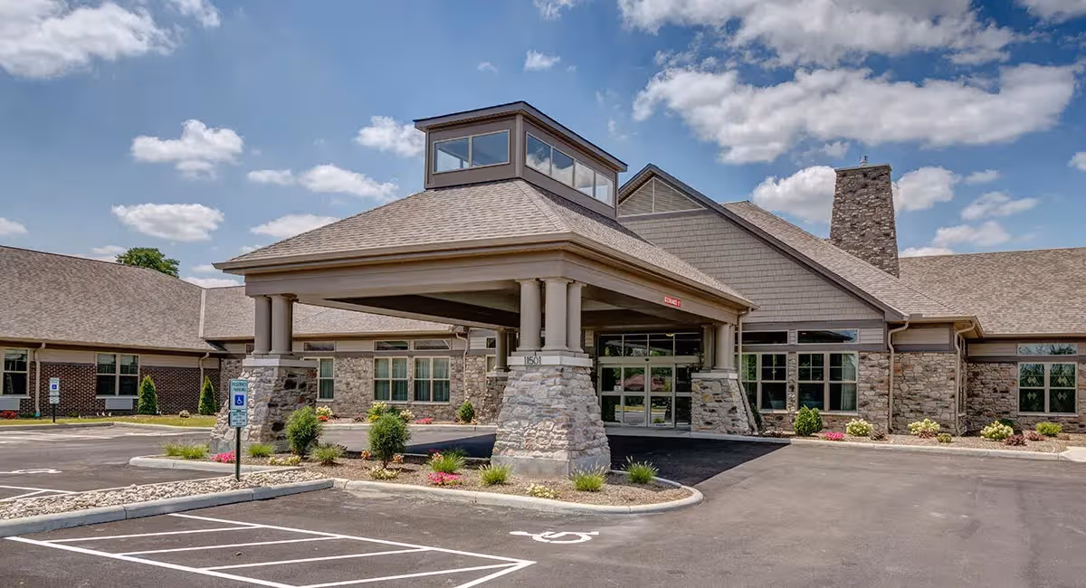 Sanctuary Pointe Nursing & Rehab Center building with stone columns, covered entrance, and parking.