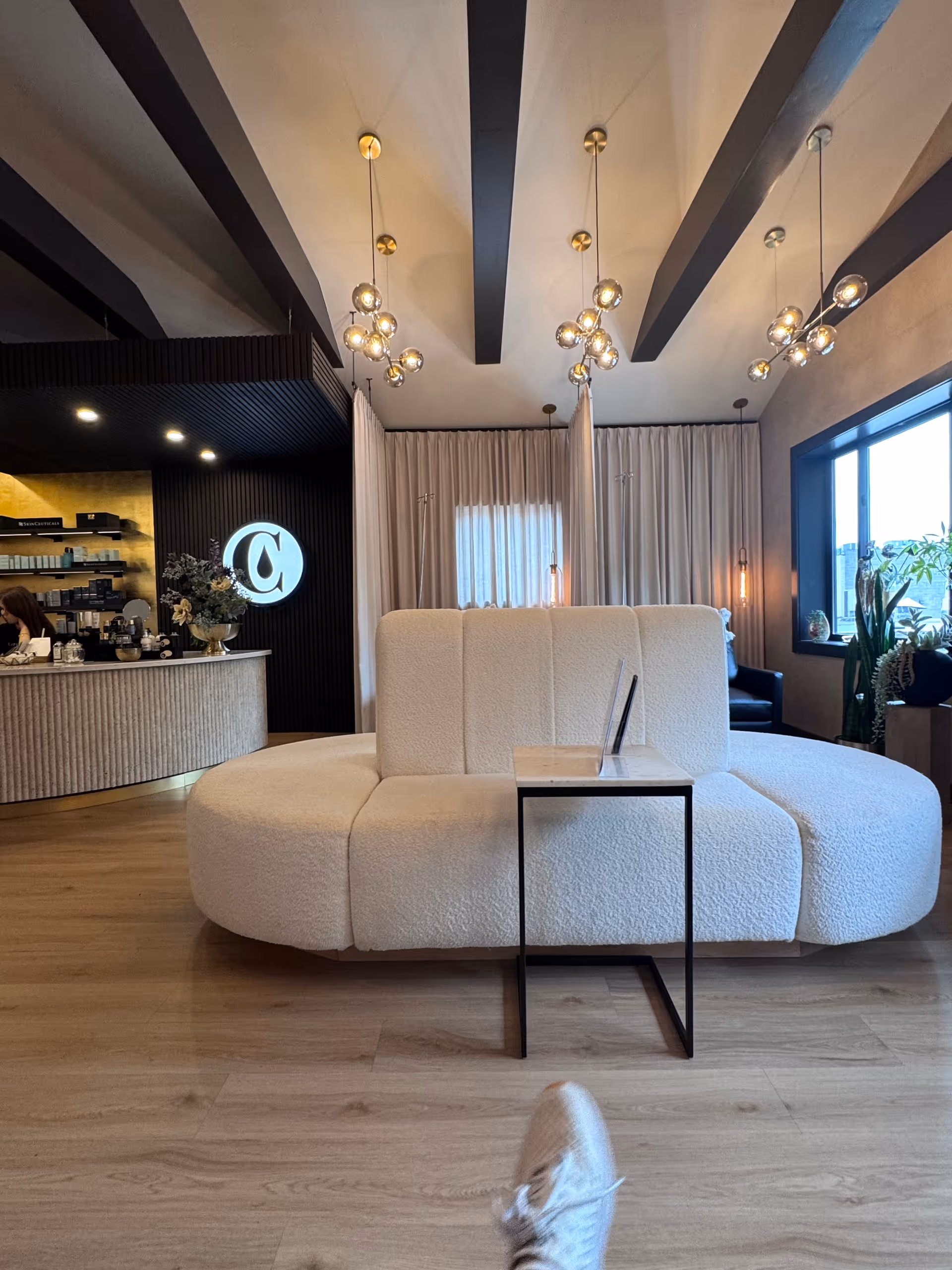 Captivate IV Wellness & Beauty Bar lounge with a white curved sofa and bar area.