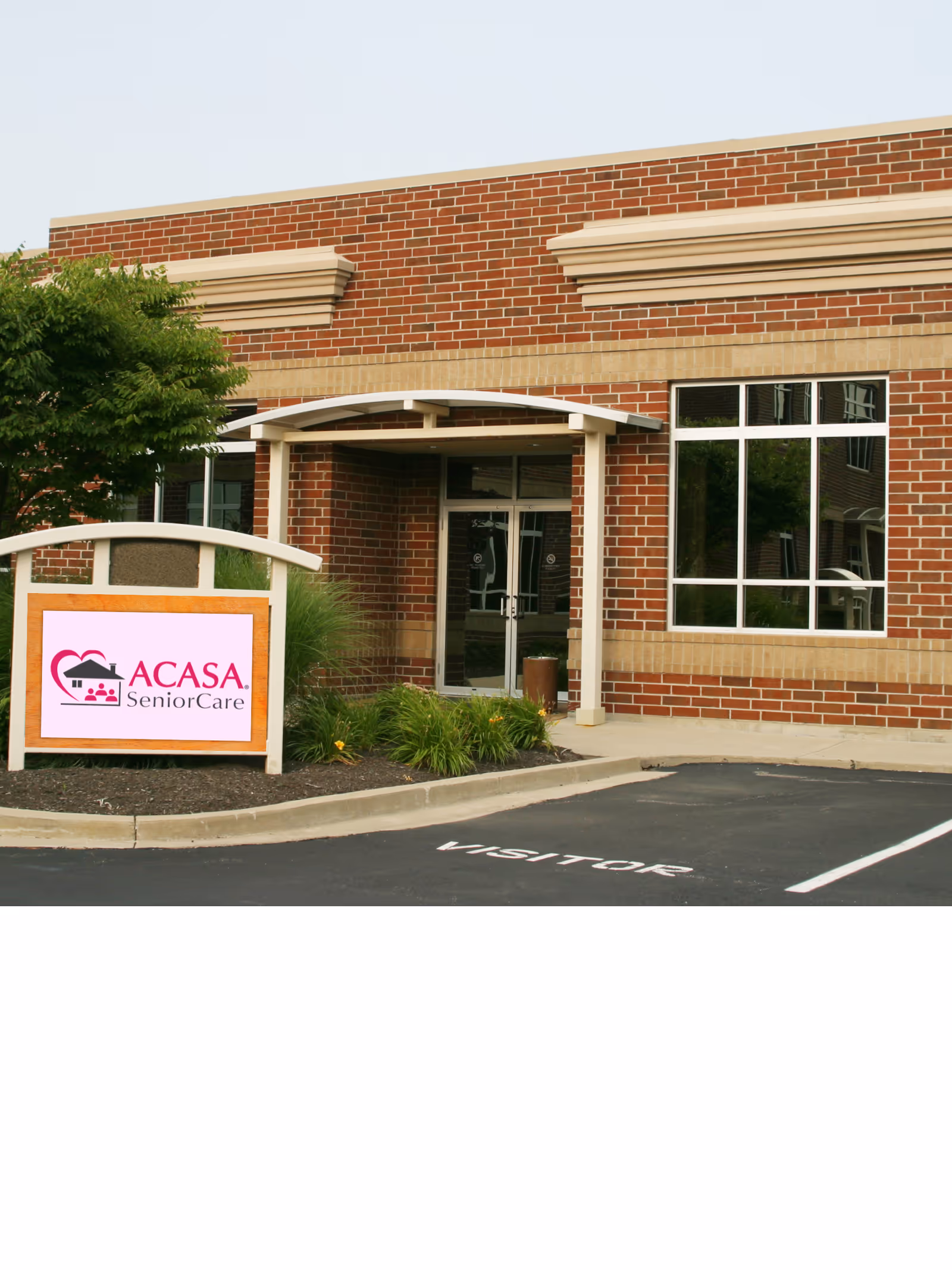 ACASA SeniorCare sign beside brick building with a glass front entrance.
