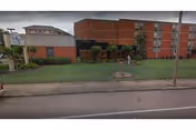 Exterior view of Midtown Center for Health and Rehabilitation with red brick building and lawn.