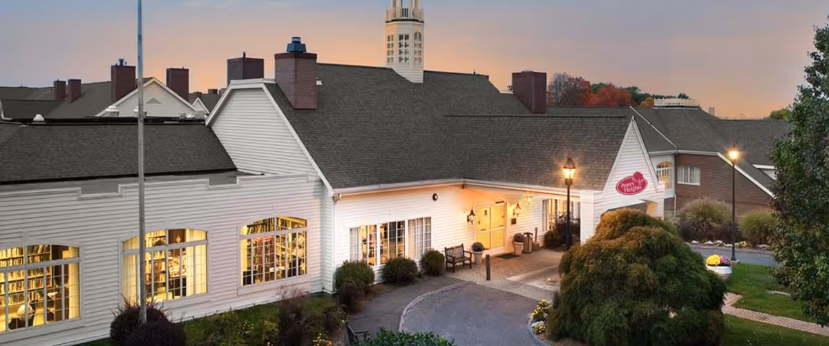 Avery Heights senior living facility front exterior with white siding, large windows, and a landscaped entrance.