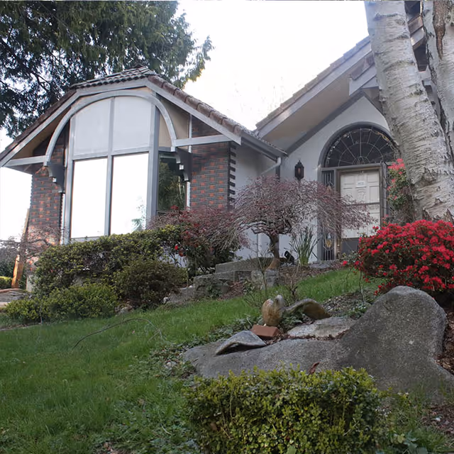Front exterior view of a residence with a landscaped yard and steps.