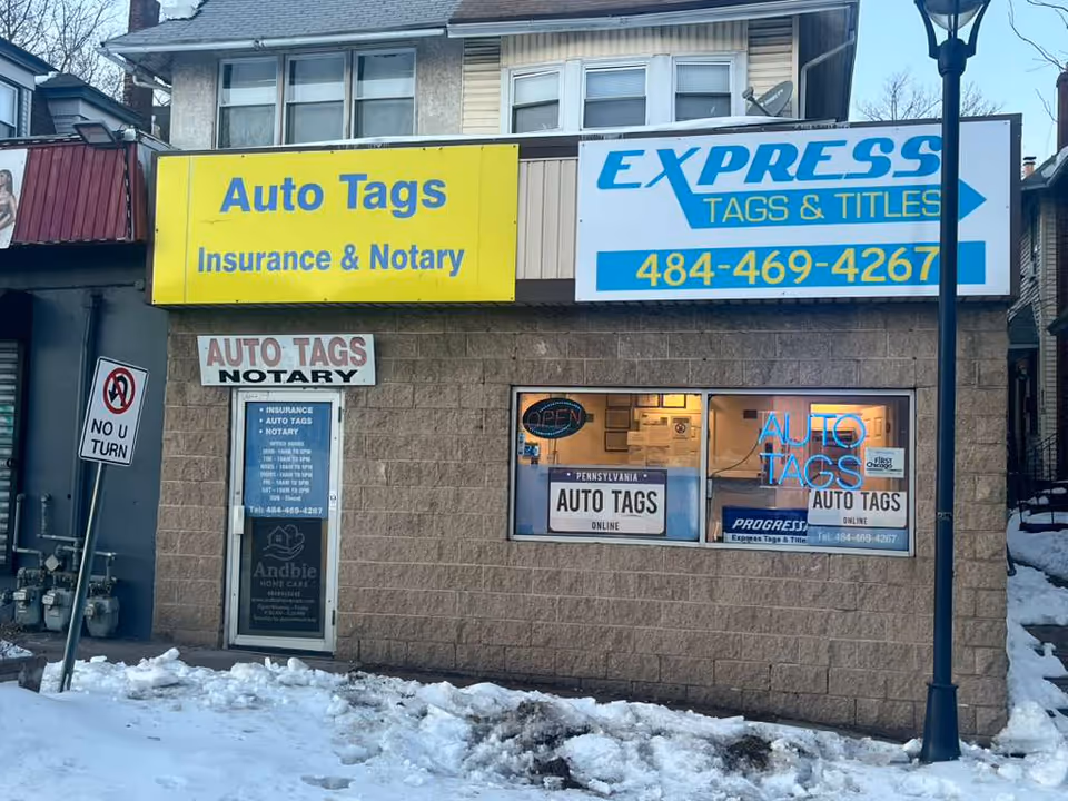 Front exterior of a storefront with yellow and blue Auto Tags signage