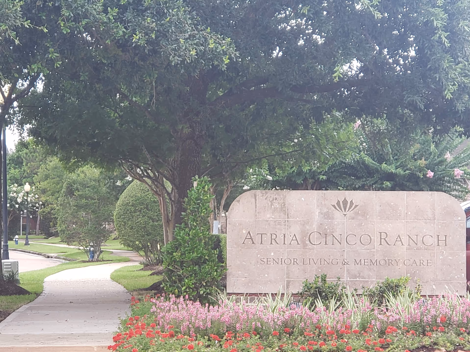 Exterior view of Atria Cinco Ranch sign with manicured landscaping.