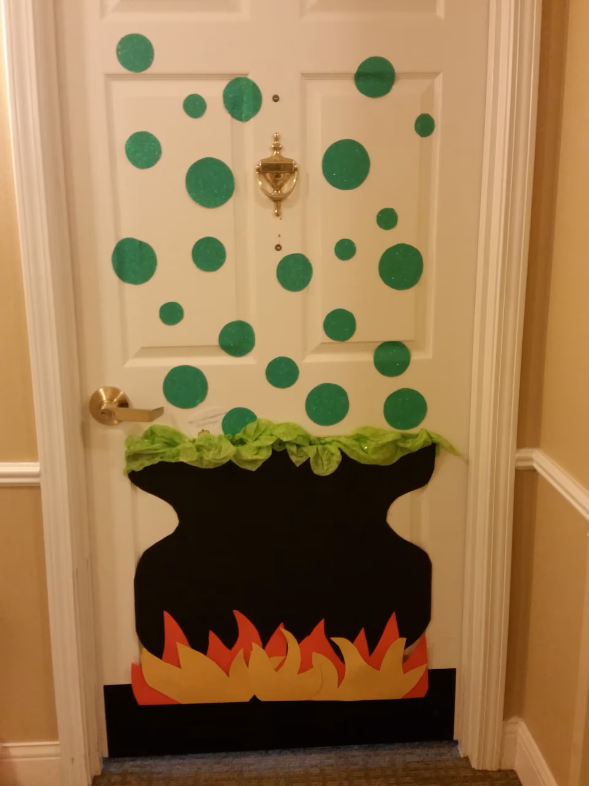A white door decorated with green polka dots and a faux fireplace cutout.