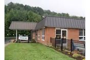 Exterior view of Mountain View Rehabilitation and Senior Living Center, brick building with entrance and lawn.
