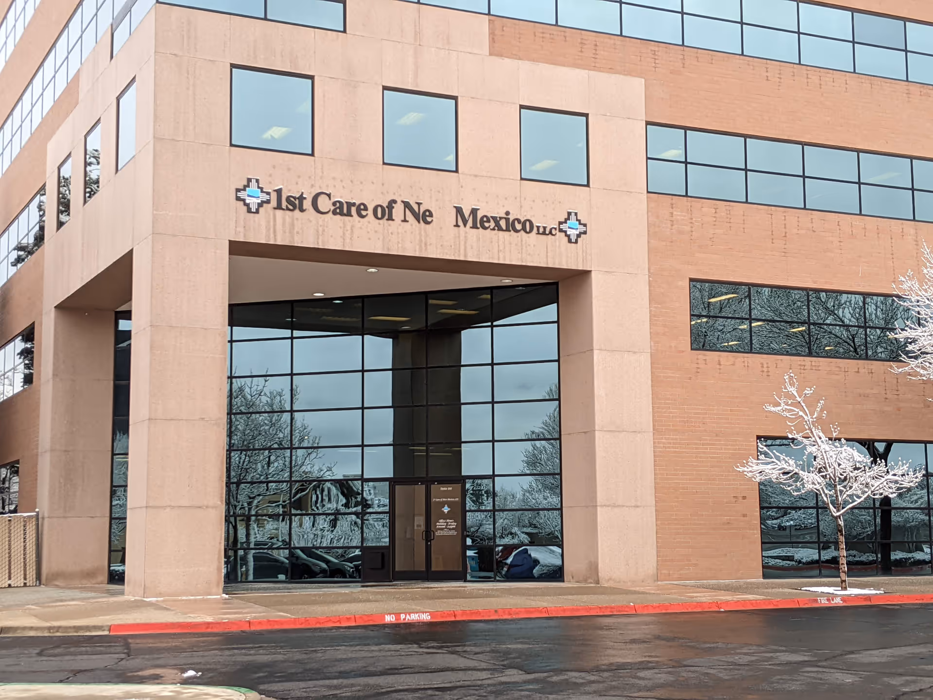 Signage for a senior care facility reading '1st Care of New Mexico' on brick building exterior.