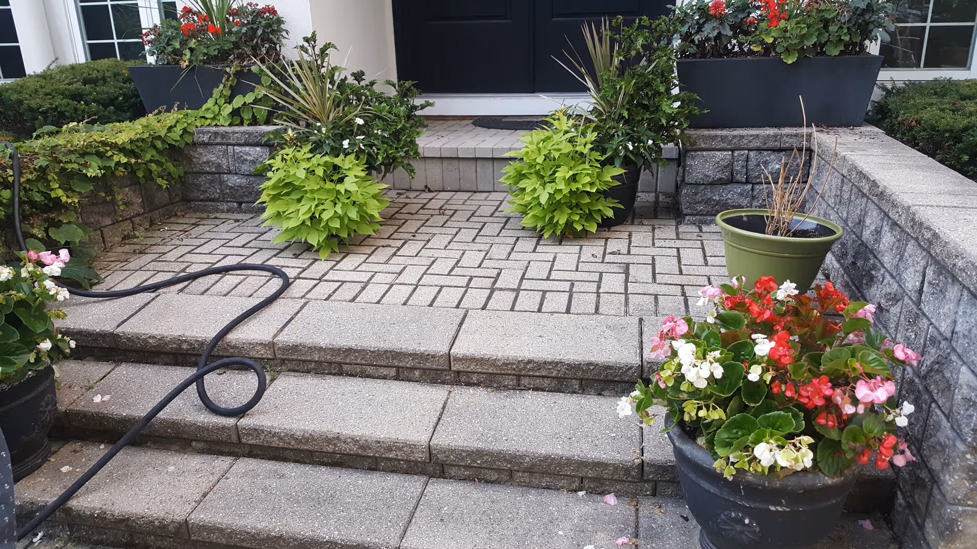 Front entrance of Mayslake Village Retirement with brick steps and potted plants.