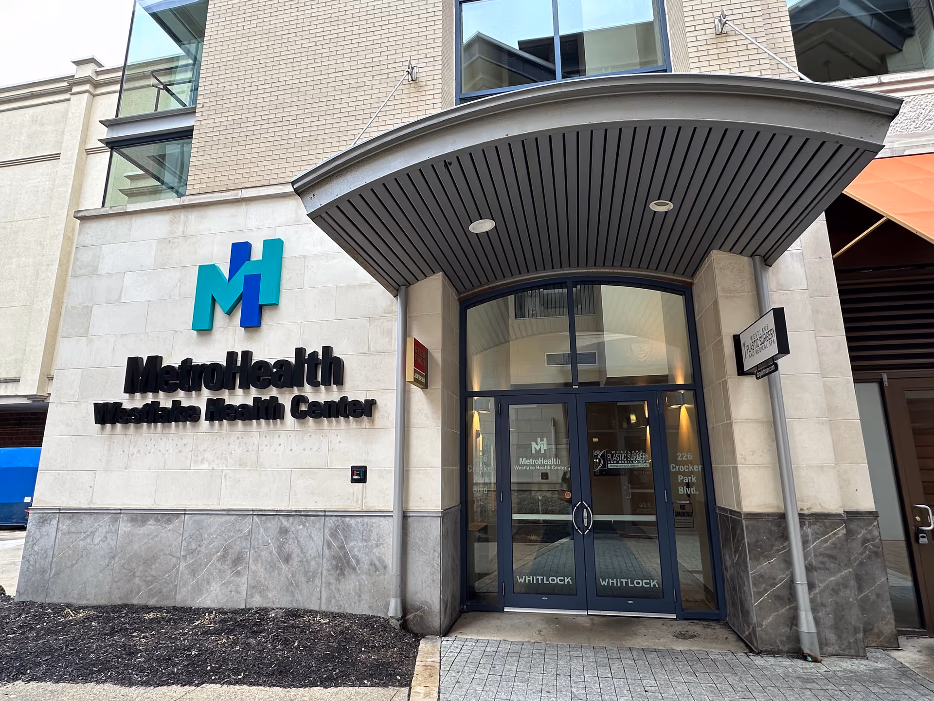 Front entrance of MetroHealth Westlake Health Center with glass doors and signage.