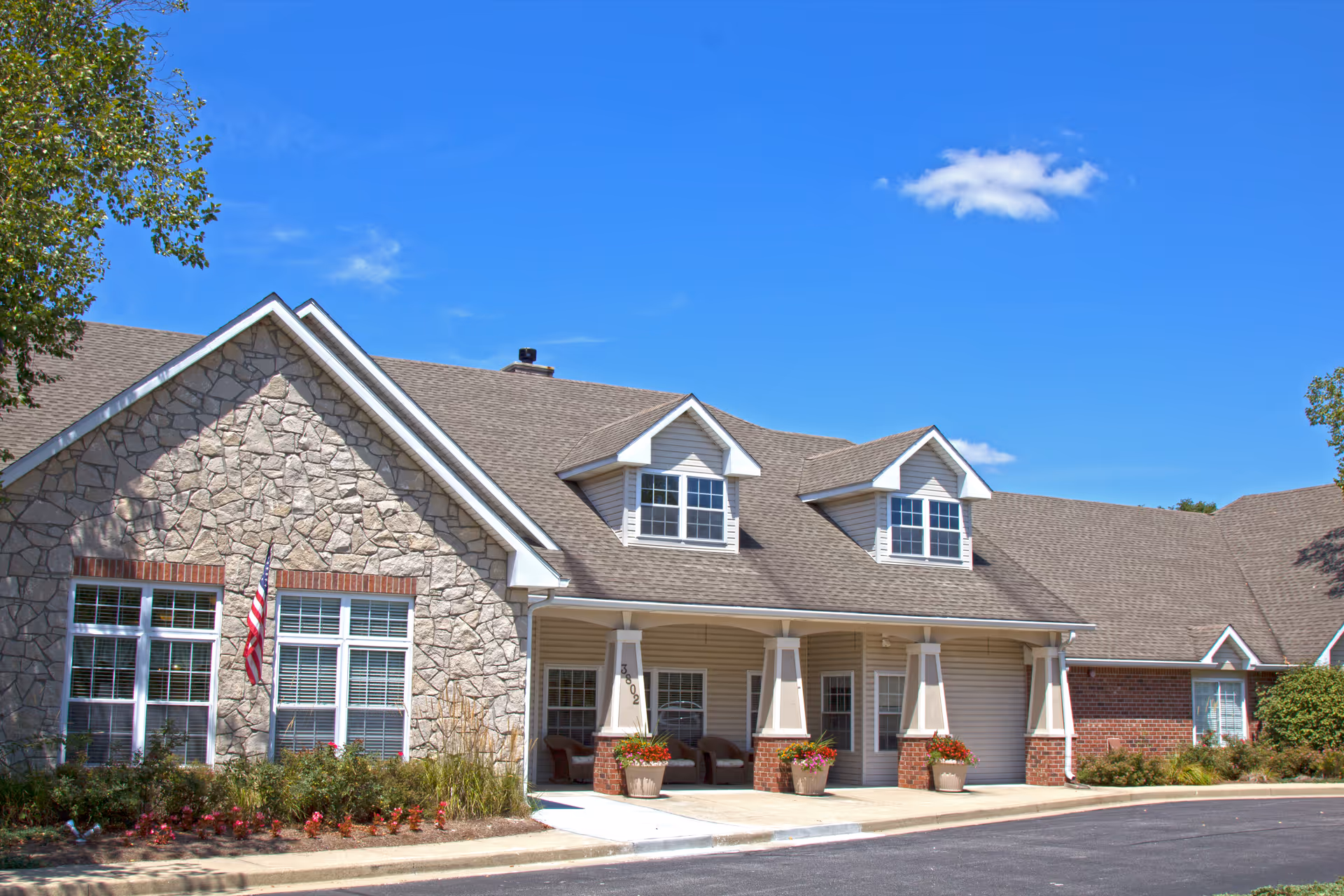 Brookdale Bloomington exterior: stone and brick building with covered entrance and front porch.