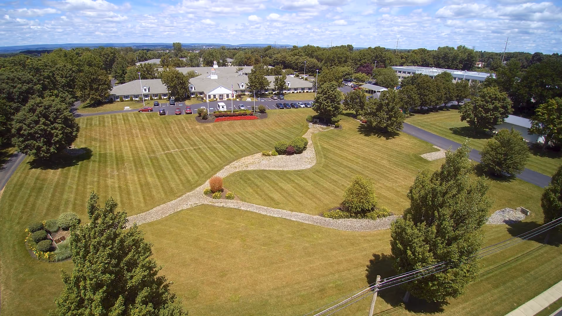 Aerial view of Country Meadows Nursing & Rehab Center with manicured grounds and parking.