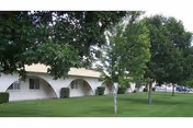 Exterior view of Hildebrand Care Center with arches and a green lawn.